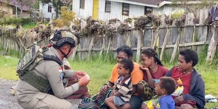 Sentuhan Humanis Satgas Damai di Sinak Melalui Pembagian Makanan Ringan kepada Warga